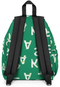 Mochila verde con patrones de texto en blanco y amarillo, con correas acolchadas negras y un asa superior para llevar. Diseño de tela texturizada.