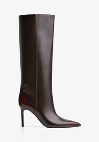 Barna bőrből készült, térdig érő csizma, hegyes orral, elegáns dizájnnal, sima felülettel és karcsú stiletto sarokkal. Az ágynál varrási részletek találhatóak.