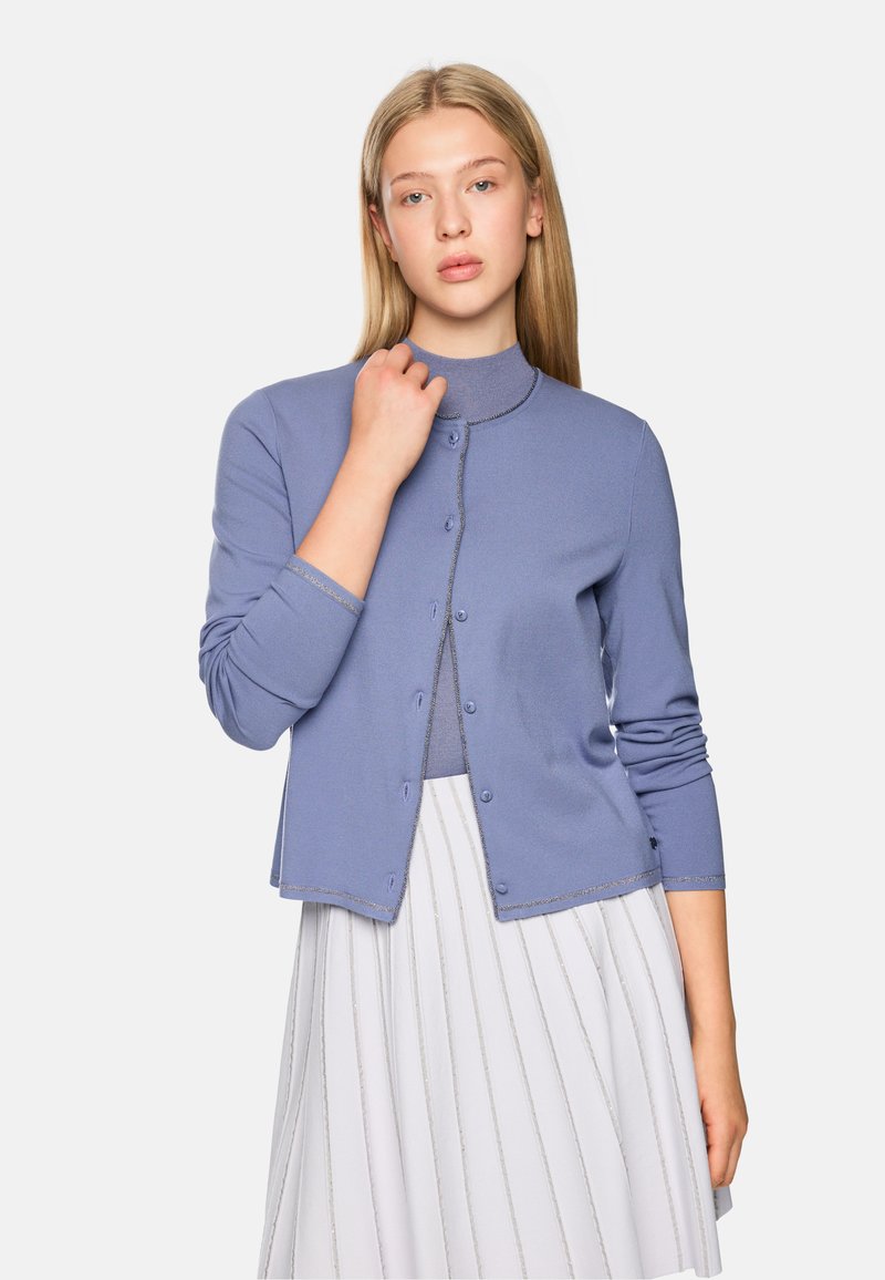 Hellblau gestrickter Cardigan mit rundem Ausschnitt, langen Ärmeln und Knopfschluss. Mit silberner Stickerei entlang der Kanten akzentuiert.