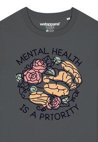 Donkergrijs t-shirt met een ontwerp van een brein omringd door roze rozen en de tekst "MENTALE GEZONDHEID IS EEN PRIORITEIT" in donker lettertype.