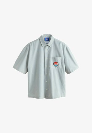 Kurzärmeliges Hemd zum Aufknöpfen mit dünnen vertikalen Streifen und einem roten und blauen runden Aufnäher auf der linken Brusttasche.