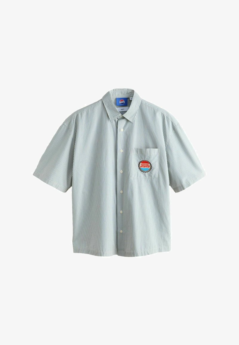Chemise à manches courtes à boutons avec fines rayures verticales et un écusson circulaire rouge et bleu sur la poche poitrine gauche.