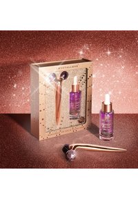 Zestaw z rolką do twarzy z ametystu i serum w eleganckim opakowaniu. Rolka ma fioletowe akcenty, a serum znajduje się w szklanej butelce z złotą nakrętką.