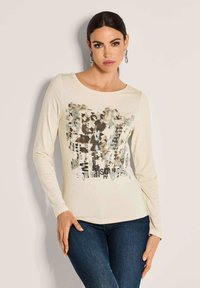 Langärmliges cremfarbenes Hemd mit einem abstrakten grafischen Design in Grau, Schwarz und Blau. Weicher Stoff mit Rundhalsausschnitt und slim Fit.