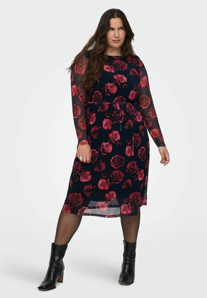 Vestido hasta la rodilla con mangas largas y transparentes, que presenta un fondo azul marino y un patrón de rosas rojas. Incluye una cintura con lazo y una ligera transparencia en el dobladillo.