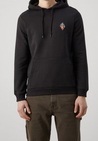 Felpa nera con cappuccio realizzata in misto cotone, dotata di tasca a canguro frontale e di un piccolo emblema grafico multicolore sul petto.