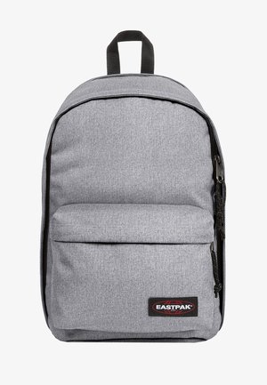 Grau stoffene Rucksack mit runder Form, Reißverschluss und Fronttasche. Verfügt über einen Handgriff oben und ein Logo-Patch in Schwarz und Rot.