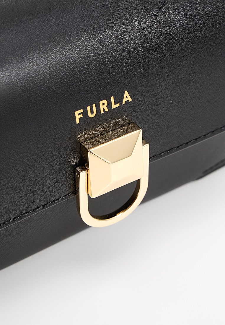 Borsa a tracolla nera in pelle con finiture dorate, dotata di un lucchetto quadrato e di un accento ad anello circolare. Nome del marchio "Furla" impresso in oro.
