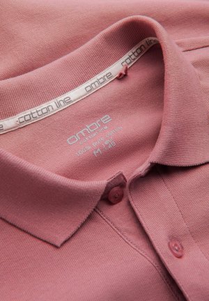 Polo en algodón de color rosa apagado, con un cuello clásico, tapeta de dos botones y un tejido texturizado. La etiqueta dice "línea de algodón ombre".