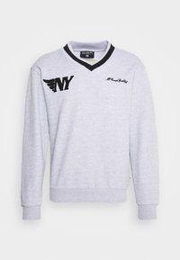 Felpa grigia con scollo a V, dettagli neri, ricamo "NY" e logo con ali sul lato sinistro, polsini e orlo a costine.