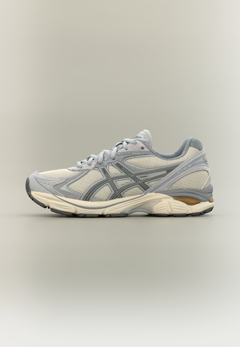 Szaro-beżowy but sportowy do biegania z panelami z siateczki, z zapięciem na sznurowadła oraz wyściełaną podeszwą zapewniającą wsparcie i komfort.