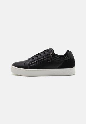 Czarny niski sneaker z białą podeszwą, bocznym zamkiem błyskawicznym, sznurowaniem i "Calvin Klein Jeans" wytłoczonym na podeszwie i bocznym panelu.