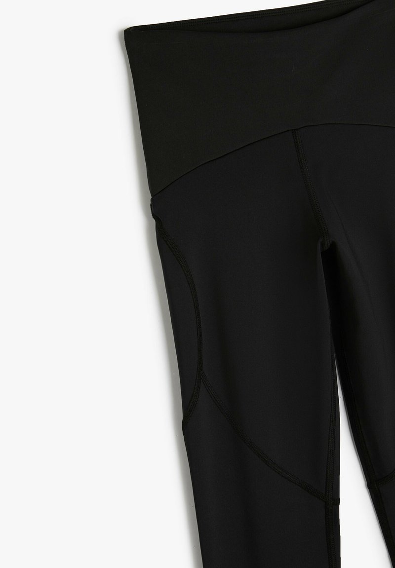 Zwarte legging met een hoge tailleband, een gladde textuur en contrasterende stiksels. Heeft een aansluitend ontwerp en naadloze zijkantdetails.