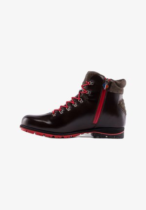Bota de senderismo de cuero marrón oscuro con cordones rojos y cremallera, suela de goma roja y detalles de tela de tweed en el cuello y el talón.