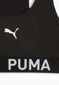 Fekete sportmelltartó rugalmas anyagból, fehér Puma logóval és fekete szalaggal, rajta fehér 'PUMA' felirattal.