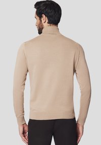 Beżowy sweter z golfem z miękkiej tkaniny, o dopasowanym kroju, z prążkowanymi mankietami i dołem. Tył prezentuje gładki, minimalistyczny styl.