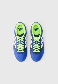 Zapatillas deportivas azules con rayas blancas, cordones verdes y un diseño elegante. Presenta un cuello acolchado y material texturizado en la parte superior.