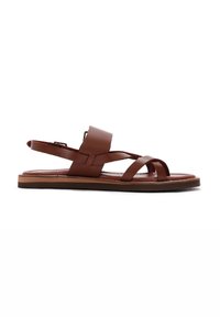 Sandale en cuir marron avec un design de brides croisées, bout ouvert, bride arrière, et semelle plate. Texture lisse avec des détails de coutures minimaux.