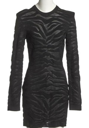 Robe noire près du corps à manches longues avec motif rayures zèbre texturé, col rond et épaules légèrement rembourrées sur un mannequin blanc.