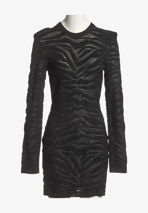 Robe noire près du corps à manches longues avec motif rayures zèbre texturé, col rond et épaules légèrement rembourrées sur un mannequin blanc.