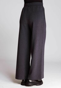 Wide-leg trousers in dark gray textured fabric, featuring a high elastic waistband and side pockets, with flat seams and a clean finish.