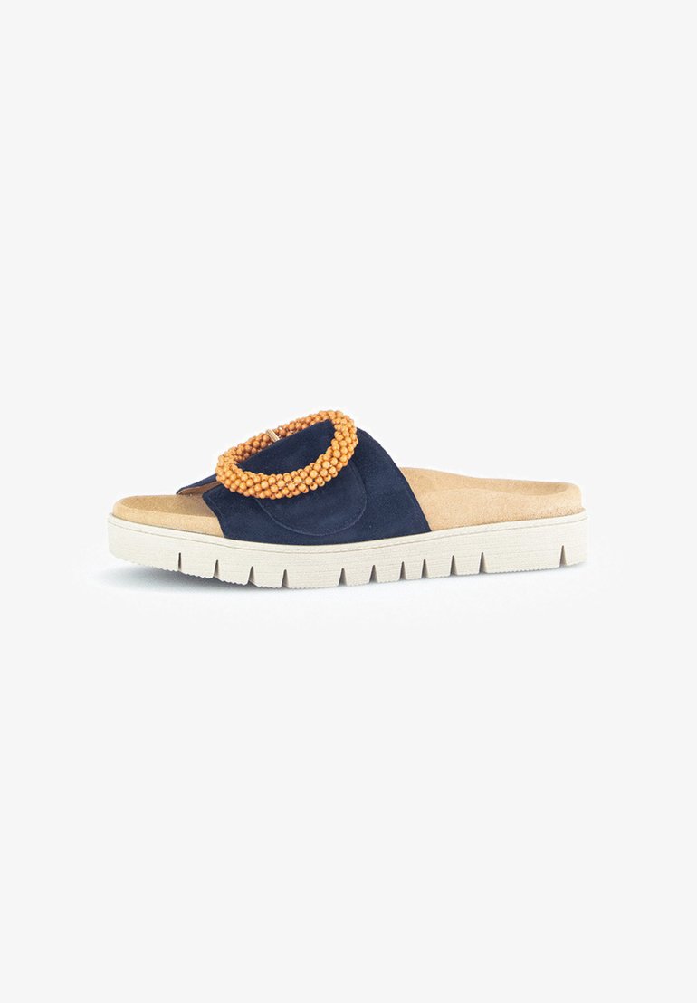 Navy blue slide sandal with a textured suede upper, accented by an orange beaded ring on the strap and a white, ridged sole.