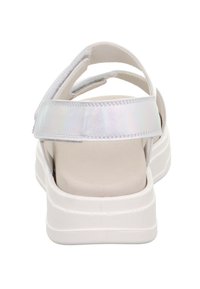 Sandale plateforme blanche avec bride de cheville irisée et semelle rembourrée, présentée de dos sur fond blanc.