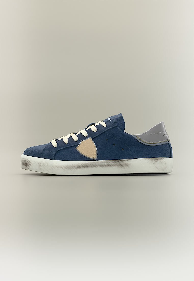 Baskets en daim bleu avec lacets blancs, empiècement écru sur le côté, talon gris et semelle en caoutchouc blanche usée, présentées de profil.