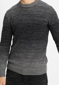 Dunkelgrauer Strickpullover mit einem allmählichen Ombre-Effekt, der von hell nach dunkel übergeht. Mit Rundhalsausschnitt und gerippten Bündchen und Säumen.