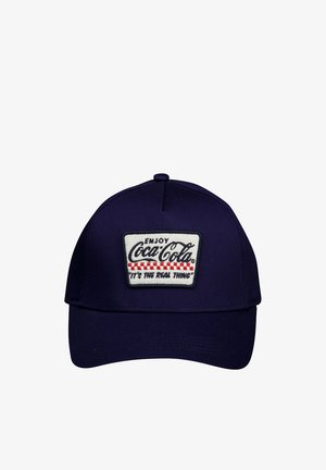 Casquette de baseball bleu marine avec un écusson blanc affichant "Enjoy Coca-Cola" et un motif à carreaux rouges, ainsi que la phrase "It's the real thing."