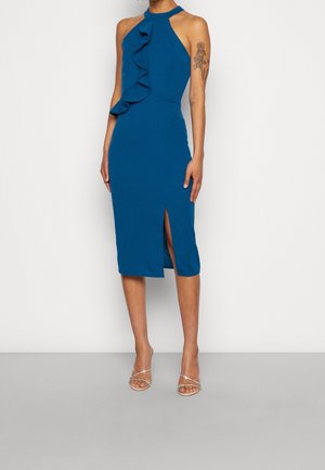Niebieska sukienka na szyi z falbaną z przodu, dopasowana sylwetka, długość do połowy łydki i rozcięcie na udzie. Gładki materiał.
