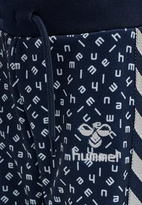 Marina atletiska shorts med en vit geometrisk print och logotyp, med dragsko i midjan och texturerade sidopaneler.