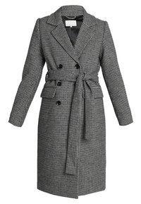 Černobílý kabát s houndstooth vzorem, dvouřadý s páskem v pase, velkými klopami a dvěma předními kapsami.