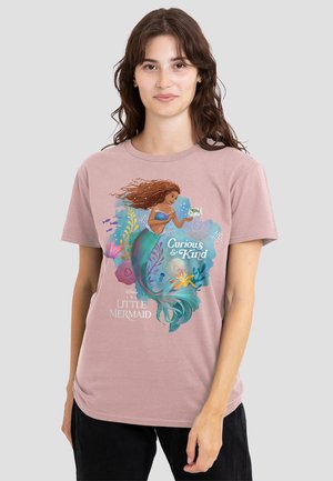 Light pink t-shirt featuring a Disney mermaid graphic with vibrant blues, greens, and plants, text “Curious & Kind,” soft cotton fabric.