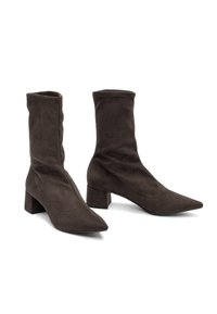Stivali alla caviglia in suede marrone con punta appuntita, stivale aderente e robusto tacco a blocco. Texture liscia e dettagli minimi.