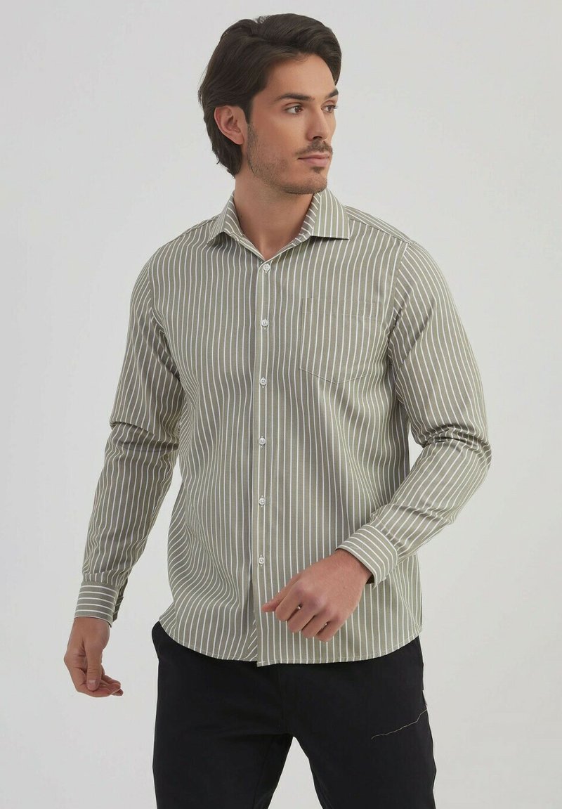 Chemise boutonnée à rayures en vert olive et blanc, avec un col, des manches longues et une poche poitrine, fabriquée dans un tissu lisse.