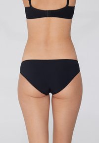 Schwarze Bikinihose mit einem schlichten Design, featuring eine glatte Textur und einen tiefen Schnitt. Der Bund ist sauber genäht für Langlebigkeit.