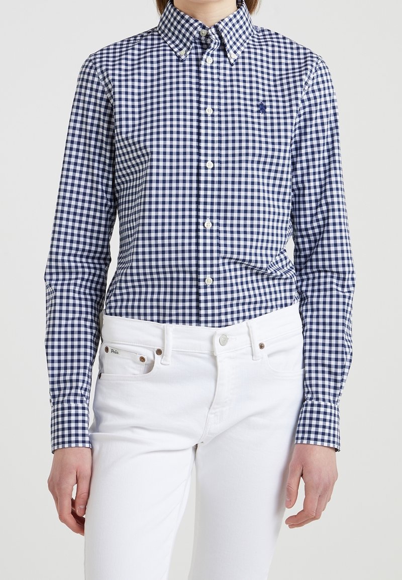 Marinblå och vit rutmönstrad skjorta med klassisk krage, i kombination med vita jeans. Har långa ärmar och en minimal logotypdetalj.