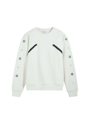 Sudadera blanca de manga larga con ribete en zigzag negro en el pecho y motivos de sol y círculos en ambas mangas.