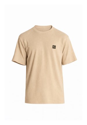 Camiseta de punto beige de manga corta con cuello redondo y pequeño logo cuadrado en negro y dorado en el pecho izquierdo.