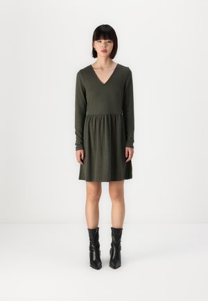 Robe à manches longues, de couleur vert foncé, avec un décolleté en V, une taille froncée et une jupe évasée. Stylée avec des bottes noires jusqu'au genou. Texture lisse, design décontracté.