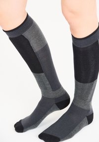 Knähöga strumpor med en färgblockdesign i nyanser av svart, grått och mörkgrått. Tillverkade av ett texturerat, elastiskt material.