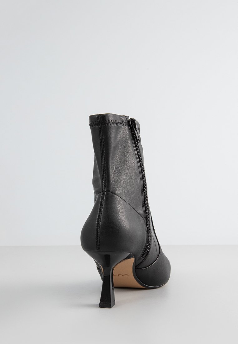 Schwarze Lederstiefelette mit einem schmäler werdenden Absatz, Reißverschluss und glatter Textur. Besitzt eine dekorative Naht entlang der Naht.