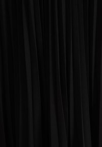 Tessuto nero con pieghe verticali, texture liscia e design fluido. Il materiale appare leggero e si drappeggia in modo elegante.