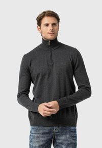 Dunkelgrauer Pullover mit Reißverschlusskragen, geripptem hohen Kragen, langen Ärmeln und tailliertem Design. Weiche Textur und minimalistische Markendetails.