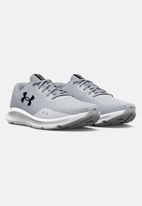 Baskets de sport grises avec une tige en mesh respirant, bout rond, semelle intermédiaire blanche et accents de logo noirs. Comprend des lacets et une semelle texturée.