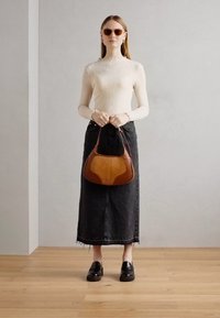 Cremefarvet ribbet langærmet top, sort denim maxiskørt, oversized brun og sort lædertaske samt sorte chunky loafers. Tekstureret og lagdelt design.
