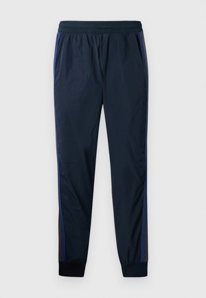 Marine treningsbukser med marineblå og grå sidestripe, elastisk midje og tettsittende mansjetter ved anklene. Glatt, lett materiale.
