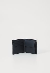 Marineblå lærpung med flere kortlommer og knappet myntholder. Glatt tekstur, to-delt design, med subtil merkevare på siden.
