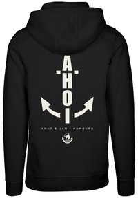 Black hoodie featuring a large white graphic with the word "AHOI" and an anchor design, along with the text "Knut & Jan | Hamburg."